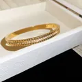 Vue détaillée d'un bracelet en acier inoxydable doré orné de zircons scintillants - Style 10 Rainuré Géométrique / Or