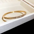 Gros plan d'un élégant bracelet en acier doré avec incrustations de zircons cubiques - Style 8 Pavé Taille Carrée / Or