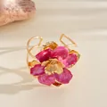 Vue détaillée de la texture de la fleur en émail rose plissée sur la bague dorée - Bracelet manchette / Rose rouge