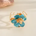 Bague florale dorée élégante avec détails en émail bleu et finition métallique texturée. - Bracelet manchette / Bleu