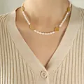 Barocke Süßwasserperlenkette mit goldenen hohlen Anhängern am Hals des Models - 40+5cm / Goldener Glücksbringer