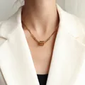Collier en acier doré à deux mailles avec pendentif cylindre gravé porté par un mannequin - 40+5cm / Style Cylindre à Huile Goutte d'Or (P1010)
