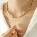 Golden chunky chain necklace with white pearls and black beads on a female model - 40+5cm