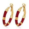 Detailed macro view of red enamel and gold bamboo-style stainless steel hoop earrings - Red