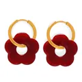 Orecchini a cerchio dorati con pendenti a fiore in resina rosso scuro su sfondo bianco - Orecchini / Rosso