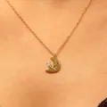 Primo piano di un'elegante collana con pendente a mezzaluna dorata con zircone sul collo - Stile Luna (04 KC Oro 8307) / Oro (Luna)