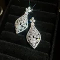 Detailopname van sprankelende zilveren druppeloorbellen met zirkoon in fluwelen doos - Stijl 68 (HE32568)