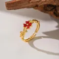 Close-up of a gold plum blossom ring with red crystals and branch-like band - Red Zirconia Plum Blossom (F1128) / Gold