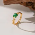 Macro view of gold ring with green four-leaf clover stones on a twig-like band - Green Zirconia Plum Blossom (F1264) / Gold