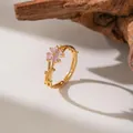 Close-up detail of a gold plum blossom ring with pink crystals and vine design. - Pink Zirconia Plum Blossom (F1265)