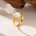 Elegant gold-tone open ring featuring a milky white stone and a halo of micro zircons. - Oval Cat's Eye Stone (F1168)
