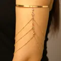 Detailopname van een goudkleurige meerlaagse kwastjesarmband met kristallen - Goud