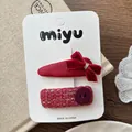 Dettaglio dei fermagli per capelli in velluto rosso e tweed su scheda bianca - Stile con fiocco rosso