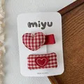 Detail van rood en wit geruite hart haarspelden op displaykaart voor meisjes - Hart Eendenbek Clips