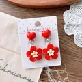 Detail shot of cute red heart and flower clip-on earrings for kids on a polka dot card - Flower Ear Clip