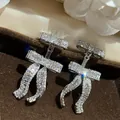 Close-up van fonkelende strikoorbellen met pavé-diamanten in een fluwelen doosje - Stijl 14 (HE32568)