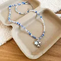 Primo piano di collana di perle con ciondolo a stella in conchiglia nei toni blu e chiaro - Collana di Perline Miste (Pendente Stella Marina) / Blu-Stella Marina
