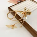 Close-up of a vintage gold floral arm cuff bracelet with intricate petal details. - Bracelet-Gold / Gold