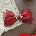 Dettaglio fiocco in velluto bordeaux con corona d'argento e strass scintillanti - Rosso Corona