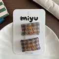 Detailed close-up of handmade pumpkin embroidery on plaid fabric hair clips for kids - Pumpkin Embroidery / Brown Plaid Pumpkin