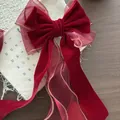 Dettaglio del fiocco per capelli in velluto bordeaux e organza con bordi dorati - Nastro Lungo Filo Oro