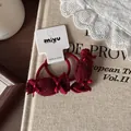 Gros plan d'élastiques à cheveux en peluche rouge foncé avec nœuds en soie élégants - Chouchou Bonbon