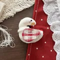 Detailopname van handgemaakte katoenen vogel haarclip met rood geruite vleugels - Zwaan Haarclip
