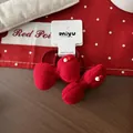 Dettaglio di elastici per capelli con fiocchi rossi in maglia e perline su fondo a pois - Corda per capelli a fiocco