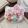 Detalle de un set de gomas de pelo infantiles con motivos animales en un cartón - Estilo Tema Gato Y Elefante
