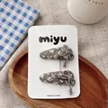 Detail of dark grey floral fabric hair clips with lace trim and tassel on a white card - Gray Waterdrop Hairpin