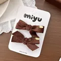 Gros plan de barrettes à nœuds en velours côtelé marron avec étiquette sur carte - 1- Nœud Marron