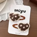 Vue détaillée de barrettes à pois marron en forme de cœur avec dentelle sur carte - Cœur à Pois Dentelle