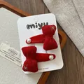 Détail de barrettes à nœuds en velours rouge avec broderie d'étoiles d'or et perles - Nœud pour cheveux