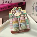 Detailaufnahme bunter Kinderhaargummis auf einer süßen Cartoon-Präsentationskarte - Basisstil / Macaron Farbe
