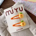 Close-up of cute orange pineapple hair clips set on a branded card for girls - Pineapple