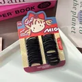 Dettaglio di elastici per capelli neri per bambini su carta da imballaggio carina - modello base / Nero