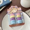 Detailopname van kleurrijke elastische haarelastiekjes voor meisjes op een wit bord - Macaron Kleur