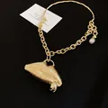 Macro view of textured gold 3D lip pendant on a chunky chain necklace detail - 3D Striped Lip Pendant (HN11704) / Gold