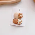 Detailed macro view of two cute bear hair clips on a white display card with fabric finish - Oval
