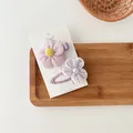 Detalle de dos pinzas para el cabello de flores púrpuras con pétalos de felpa y perla fina - Combo de Pareja de Flores