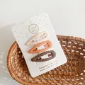 Close-up of three matte drip oil star hair clips in cream, orange and brown on card - Wavy Drop Group