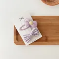 Dettaglio del set da 2 fermagli per capelli a fiocco viola con bottone giallo e quadri - Combo Fiocchetto a Quadretti