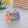 Macro view of colorful elastic hair bands in a transparent box with cartoon bear tag - Multicolor
