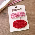 Zwei festliche Haarspangen mit rotem Karomuster und Glitzer-Tweed auf Displaykarte - Falten Pailletten Oval Set
