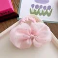Close-up of a pink seersucker bow hair tie with silver rhinestones on a decorative tray - Scrunchie Style