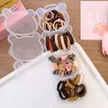 Detailed view of the bear-shaped storage box with colorful kids' hair ties and clips - Coffee