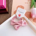 Detailed view of light pink fabric bow hair tie for girls on a white decorative plate - Solid Color Bowknot