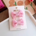 Dettaglio di fermagli per capelli con fiocco rosa a scacchi per bambine su carta - Fermaglio Fiocco Plaid