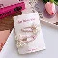 Detail of handmade sweet pink fabric hair clips with white pearl beaded bow decorations - Pink