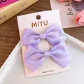 Set of two purple satin fabric bow hair clips displayed on a white product card - Purple